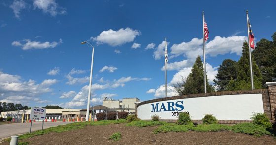 Mars Petcare building exterior with flagpoles and a blue, sunny sky